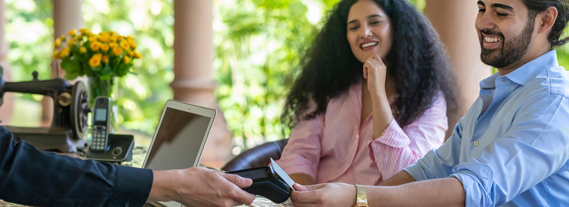 Indian couple tapping credit card to make a purchase